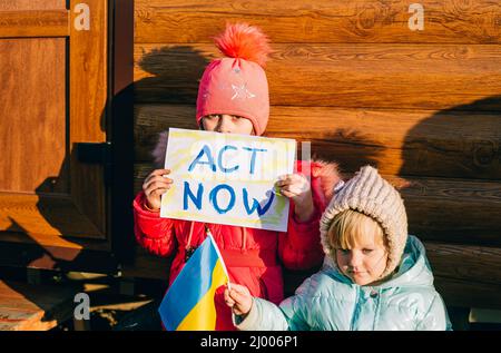 Jeunes patriotes, activistes pour enfants. Les petites filles ukrainiennes demandant d'arrêter la guerre lever bannière avec l'inscription arrêter la guerre en Ukraine Banque D'Images