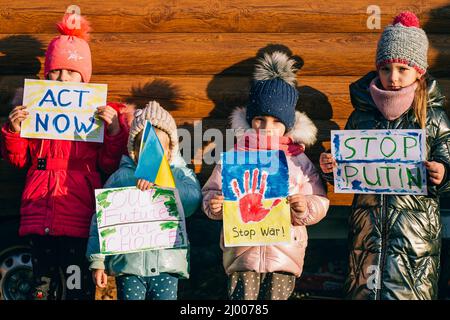 Jeunes patriotes, activistes pour enfants. Les petites filles ukrainiennes demandant d'arrêter la guerre lever bannière avec l'inscription arrêter la guerre en Ukraine Banque D'Images