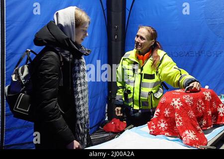 Przemysl, Pologne. 15th mars 2022. Alexandra Ohland (r) d'Essen, du sauvetage des animaux allemands, prend soin du chat d'une femme qui s'est enfui d'Ukraine au poste frontière de Medyka. Beaucoup de personnes qui fuient la guerre d'Ukraine arrivent ici en train à la frontière polonaise et continuent leur voyage en bus ou autrement. Credit: Christoph Reichwein/dpa/Alay Live News Banque D'Images