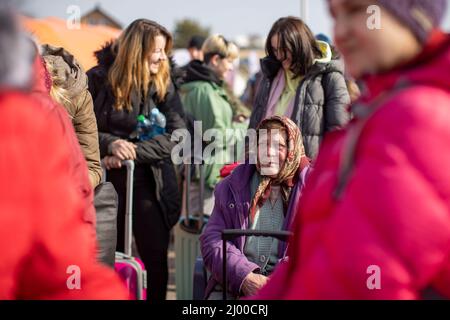 Przemysl, Pologne. 15th mars 2022. Les réfugiés d'Ukraine attendent peu après la frontière avec l'Ukraine, au poste frontière de Medyka, qu'ils soient reçus par des assistants. Beaucoup de personnes qui fuient la guerre d'Ukraine arrivent ici en train à la frontière polonaise et continuent leur voyage en bus ou autrement. Credit: Christoph Reichwein/dpa/Alay Live News Banque D'Images