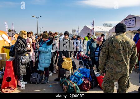 Przemysl, Pologne. 15th mars 2022. Les réfugiés d'Ukraine attendent peu après la frontière avec l'Ukraine, au poste frontière de Medyka, qu'ils soient reçus par des assistants. Beaucoup de personnes qui fuient la guerre d'Ukraine arrivent ici en train à la frontière polonaise et continuent leur voyage en bus ou autrement. Credit: Christoph Reichwein/dpa/Alay Live News Banque D'Images