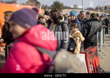 Przemysl, Pologne. 15th mars 2022. Les réfugiés d'Ukraine avec leurs enfants attendent peu de temps après la frontière avec l'Ukraine, au poste frontière de Medyka, pour être reçus par les aides. Beaucoup de personnes qui fuient la guerre d'Ukraine arrivent ici en train à la frontière polonaise et continuent leur voyage en bus ou autrement. Credit: Christoph Reichwein/dpa/Alay Live News Banque D'Images