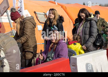 Przemysl, Pologne. 15th mars 2022. Les réfugiés d'Ukraine attendent peu après la frontière avec l'Ukraine, au poste frontière de Medyka, qu'ils soient reçus par des assistants. Beaucoup de personnes qui fuient la guerre d'Ukraine arrivent ici en train à la frontière polonaise et continuent leur voyage en bus ou autrement. Credit: Christoph Reichwein/dpa/Alay Live News Banque D'Images