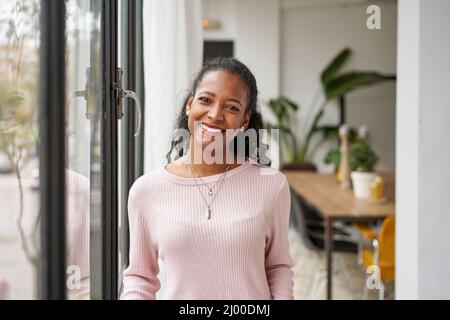 Joyeuse belle femme africaine professionnelle debout à la maison dans le bureau regardant l'appareil photo. Bonne confiante entrepreneur dame riant visage posant Banque D'Images
