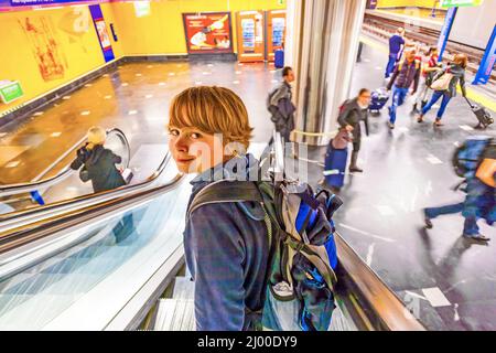 Garçon sur un escalier mobile dans la gare Banque D'Images