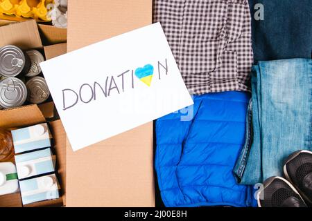 Don pour les personnes de l'Ukraine. Boîtes de dons avec vêtements et nourriture. Les bénévoles collectent des dons pour les réfugiés Banque D'Images