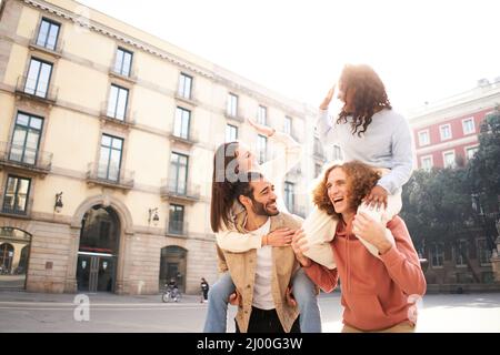 Deux beaux couples européens en piggyback riant et s'amusant. Concept d'amitié Banque D'Images