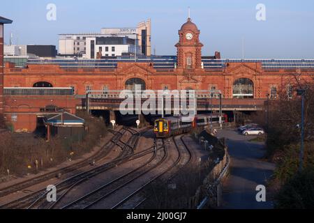 2 trains East Midlands classe 158 trains 158785 + 158812 quittant la gare de Nottingham avec le bâtiment de la grande gare derrière. Banque D'Images