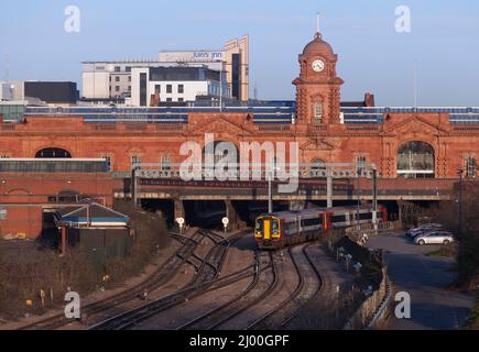 2 trains East Midlands classe 158 trains 158785 + 158812 quittant la gare de Nottingham avec le bâtiment de la grande gare derrière. Banque D'Images