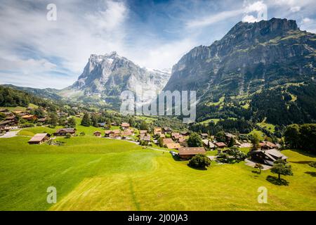 Vue ensoleillée sur le village alpin Eiger. Scène pittoresque. Attraction touristique populaire. Lieu place Alpes suisses, vallée de Grindelwald dans l'Oberla bernois Banque D'Images