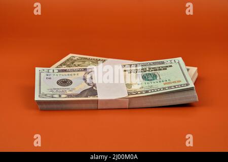 Lots de billets en dollars sur une table de couleur orange. Banque D'Images