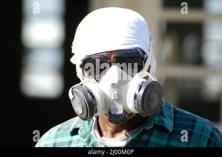 Homme portant un masque de sécurité et de travail de mise sur la reconstruction de l'allée avec commrcial grinder Banque D'Images