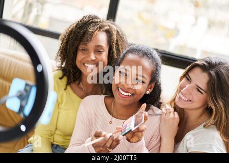 Trois jeunes belles femmes et la beauté professionnelle de faire l'artiste vlogger ou Blogger enregistrement maquillage tutorial à partager sur le site Web ou les médias sociaux. Banque D'Images