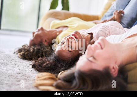 Gros plan Femme visage les femmes sourient à la maison de canapé. Trois jeunes femmes multiculturelles qui s'amusent ensemble à l'intérieur dans le salon décontracté Banque D'Images