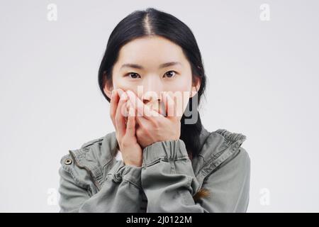 Woah Comment avez-vous fait cela. Photo studio d'une jeune femme qui a l'air choquée sur fond gris. Banque D'Images