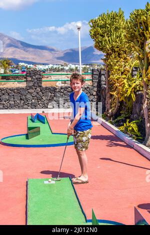 Garçon aime à jouer Mini-Golf Banque D'Images