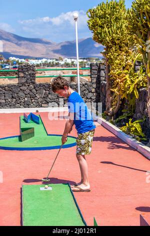 Garçon aime à jouer Mini-Golf Banque D'Images