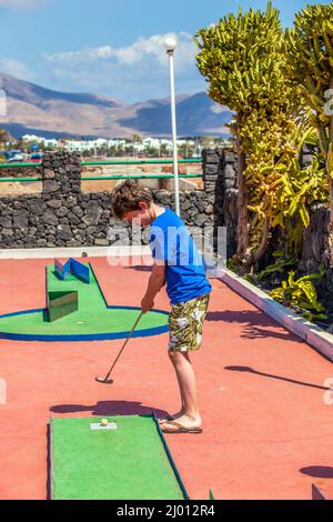 Garçon aime à jouer Mini-Golf Banque D'Images