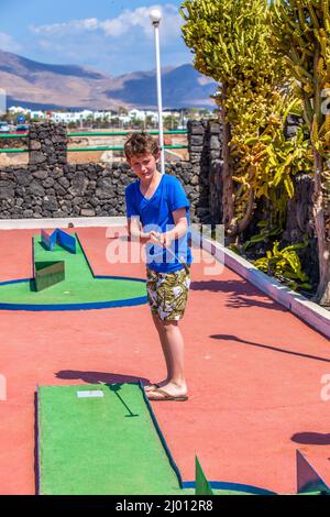 Garçon aime à jouer Mini-Golf Banque D'Images