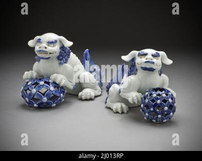 Paire d'Okimono sous forme de Lions chinois sur des balles percées. Japon, 19th siècle. Céramique. Matériel Hirado; porcelaine avec glaçures blanches et bleues Banque D'Images