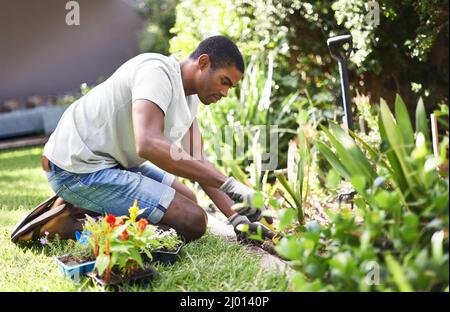 Résoudre le problème. Coupe courte d'un beau jeune homme jardinant. Banque D'Images
