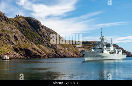 Le navire de guerre Frégate militaire Halifax 330 du HMSC est entré dans le port près d'une côte et d'une montagne rocheuses. Le navire de la marine canadienne est un militaire armé. Banque D'Images