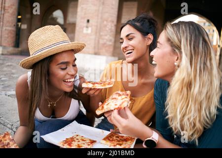 Drôle de groupe de trois amies qui mangent de la pizza dans la ville. Les gens qui apprécient le week-end et les vacances en été Banque D'Images