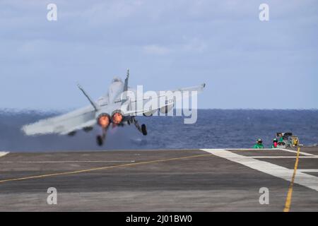 Mer des Philippines, États-Unis. 09 mars 2022. Un avion de chasse F/A-18E Super Hornet de la Marine américaine, affecté au chasseur 14 de l'escadron de chasse Tophatters of Strike, sort du pont de vol du porte-avions USS Abraham Lincoln de la classe Nimitz lors des opérations de routine, le 9 mars 2022, en mer des Philippines. Crédit : MC3 Javier Reyes/Planetpix/Alay Live News Banque D'Images