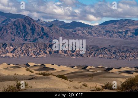 Les dunes de sable de Mesquite Flat avec les montagnes arrière à l'ombre des nuages Banque D'Images