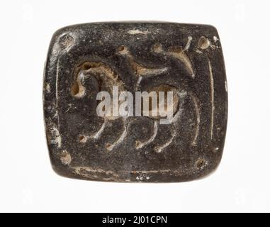 Cachet, Tabloïd. Iran, Bactria ou Mésopotamie, vers 2nd millénaire avant J.-C. Outils et équipement; joints. Serpentin noir Banque D'Images