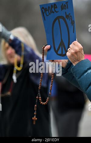 Dallas, États-Unis. 15th mars 2022. Une femme tient un écriteau qui dit « la paix pas la guerre » et un rosaire lors d'un rassemblement pour mettre fin à la guerre en Ukraine. Un groupe de paroissiens se rassemblent dans le centre de Dallas, PA. Après une heure de prière à l'église de la porte du ciel. L'évêque Joseph Bambera a appelé les Églises catholiques du diocèse de Scranton à participer à une heure de prière pour mettre fin à la guerre en Ukraine. Crédit : SOPA Images Limited/Alamy Live News Banque D'Images