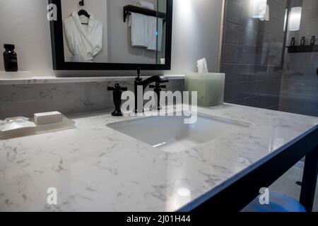 Angle, accent sélectif sur un moderne robinet-lavabo noir de salle de bains à l'intérieur d'un hôtel haut de gamme et luxueux Banque D'Images