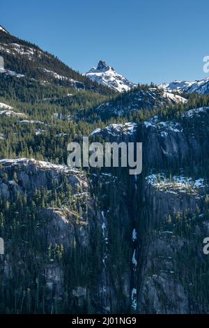 Prenez la photo du sommet de la montagne surplombant les falaises abruptes et la chute d'eau gelée. Banque D'Images