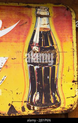 Vintage Coca Cola Soft Drink Company annonçant l'affiche de métal sur le mur de bois de planche. Banque D'Images