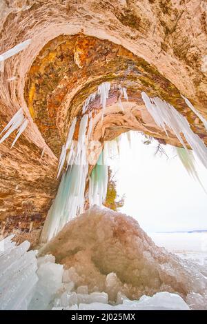 Détail de l'entrée de la grotte de glace avec des formations rocheuses ondulées et des glaçons congelés Banque D'Images