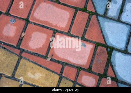 Matériaux de construction, surface de route, trottoir en pierres colorées bleues, rouges et jaunes. Banque D'Images