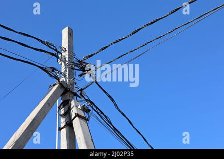 Borne de ligne d'alimentation avec fils électriques enchevêtrés et condensateurs sur fond bleu ciel. Ligne de transmission d'électricité, alimentation Banque D'Images