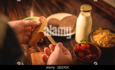 Gros plan des mains de sexe masculin épluchant une banane pour faire un petit déjeuner sain Banque D'Images