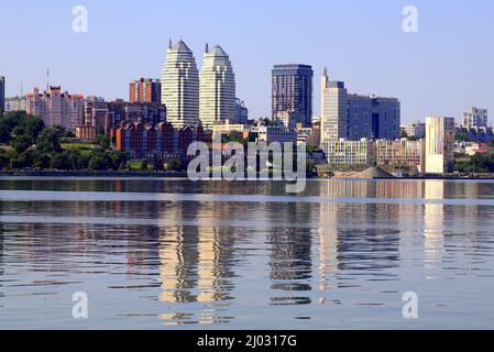 Grande ville sur les rives de la rivière large. De belles tours modernes, des bâtiments, des gratte-ciels se reflètent dans l'eau en été, au printemps. Ville ukrainienne Dnipro Banque D'Images