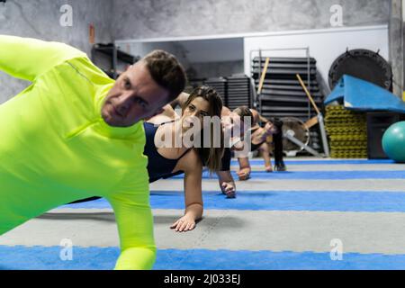 Groupe de jeunes faisant des exercices de gymnastique à la salle de gym, concept d'entraînement Banque D'Images