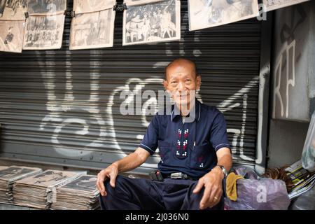 Vendeur de photos et de livres anciens. Portrait du vieil homme dans les rues de Bangkok. Banque D'Images