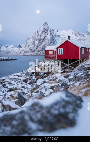 Cabanes de pêcheurs rouges couvertes de neige au crépuscule, Hamnoy, comté de Nordland, îles Lofoten, Norvège, Scandinavie, Europe Banque D'Images