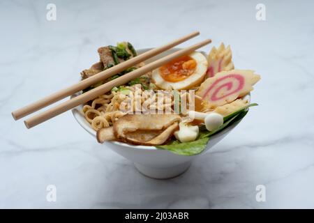 Bol à soupe de ramen avec baguettes sur table en marbre Banque D'Images