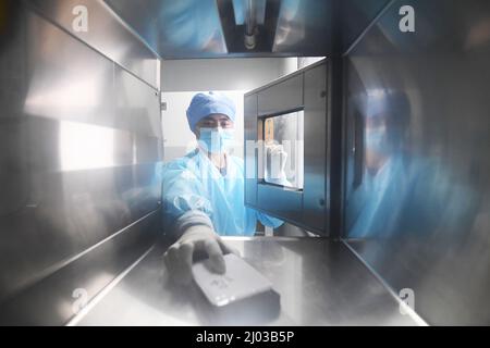 GUIYANG, CHINE - le 15 MARS 2022 - Un membre du personnel démontre le transfert du réactif d'analyse des acides nucléiques pour le nouveau coronavirus (COVID-19) par l'intermédiaire d'un Banque D'Images