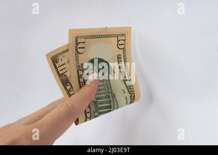 10 dollars dans la main gros plan sur un fond blanc isolé. Une facture de dix dollars Banque D'Images