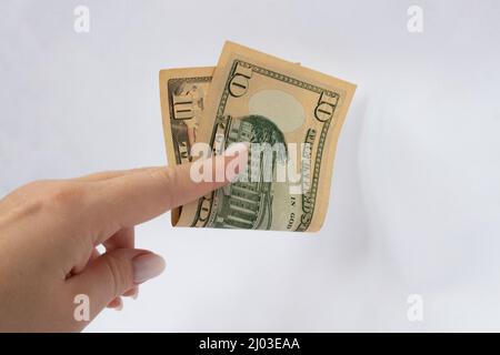 10 dollars dans la main gros plan sur un fond blanc isolé. Une facture de dix dollars Banque D'Images