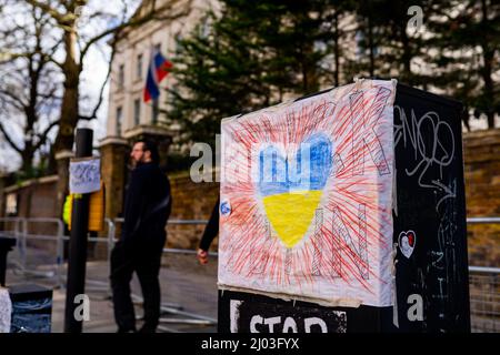 Partie d'un sanctuaire de fleurs et de messages en face de l'ambassade de Russie à Londres après l'invasion de l'Ukraine par la Russie Banque D'Images