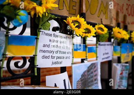 Partie d'un sanctuaire de fleurs et de messages en face de l'ambassade de Russie à Londres après l'invasion de l'Ukraine par la Russie Banque D'Images