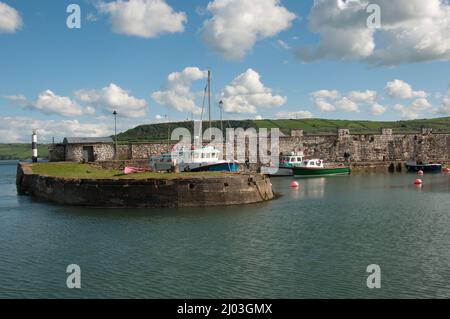 Carnlough Harbour, Co Antrim, Irlande du Nord, Royaume-Uni. Ville pittoresque et port avec bateaux, collines en arrière-plan. Banque D'Images