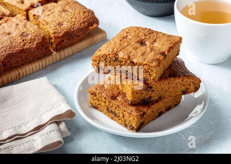 Barres de dessert Blondie Brownie avec des chips de chocolat, une pile avec du thé Banque D'Images